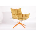 white husk chair with orange seat cushion